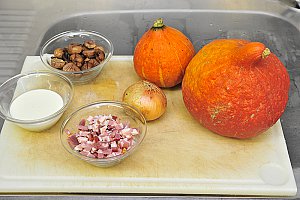 2 potimarrons dont 1 plus gros pour servir de soupière, 1 oignon, 100 g de lardons, 1 bocal de châtaignes pelées, 2 cuillères à soupe de crème fraîche, du bouillon de volaille, 2 gousses d’ail, de l’huile d’olive.
