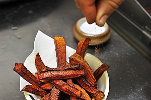 Au moment de servir, retirer le papier absorbant et saupoudrer les frites du mélange d’épices.