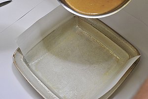 Tapisser un moule avec du papier sulfurisé beurré.